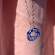 Load image into Gallery viewer, Blue molten glass pendant on pink background 
