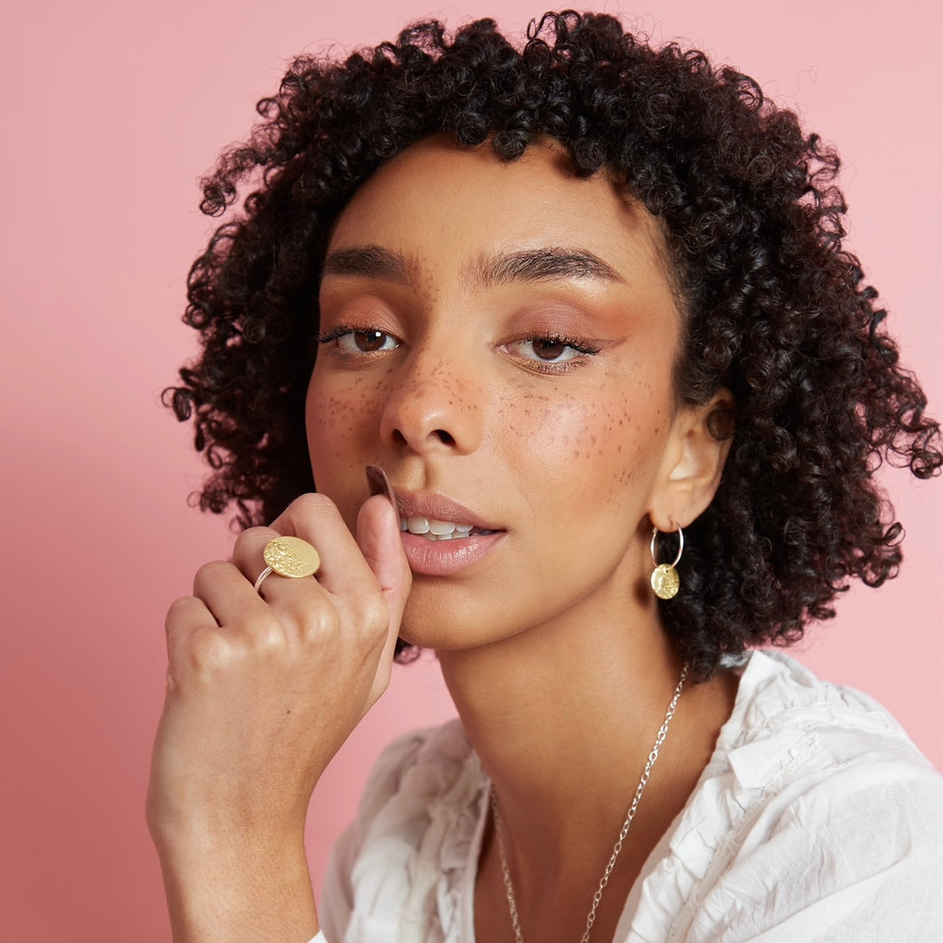 Model wearing brass full moon charm hoops 
