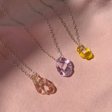 Load image into Gallery viewer, Molten glass pendants on a pink background 

